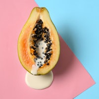 a ripe papaya on a pink and blue background